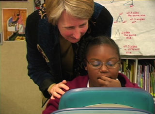 teacher with student at computer